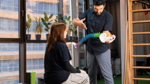 Chiropractor assessing a patient’s posture and spine motion during an initial visit